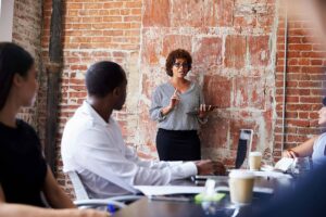 A business woman presenting to a small group of professionals