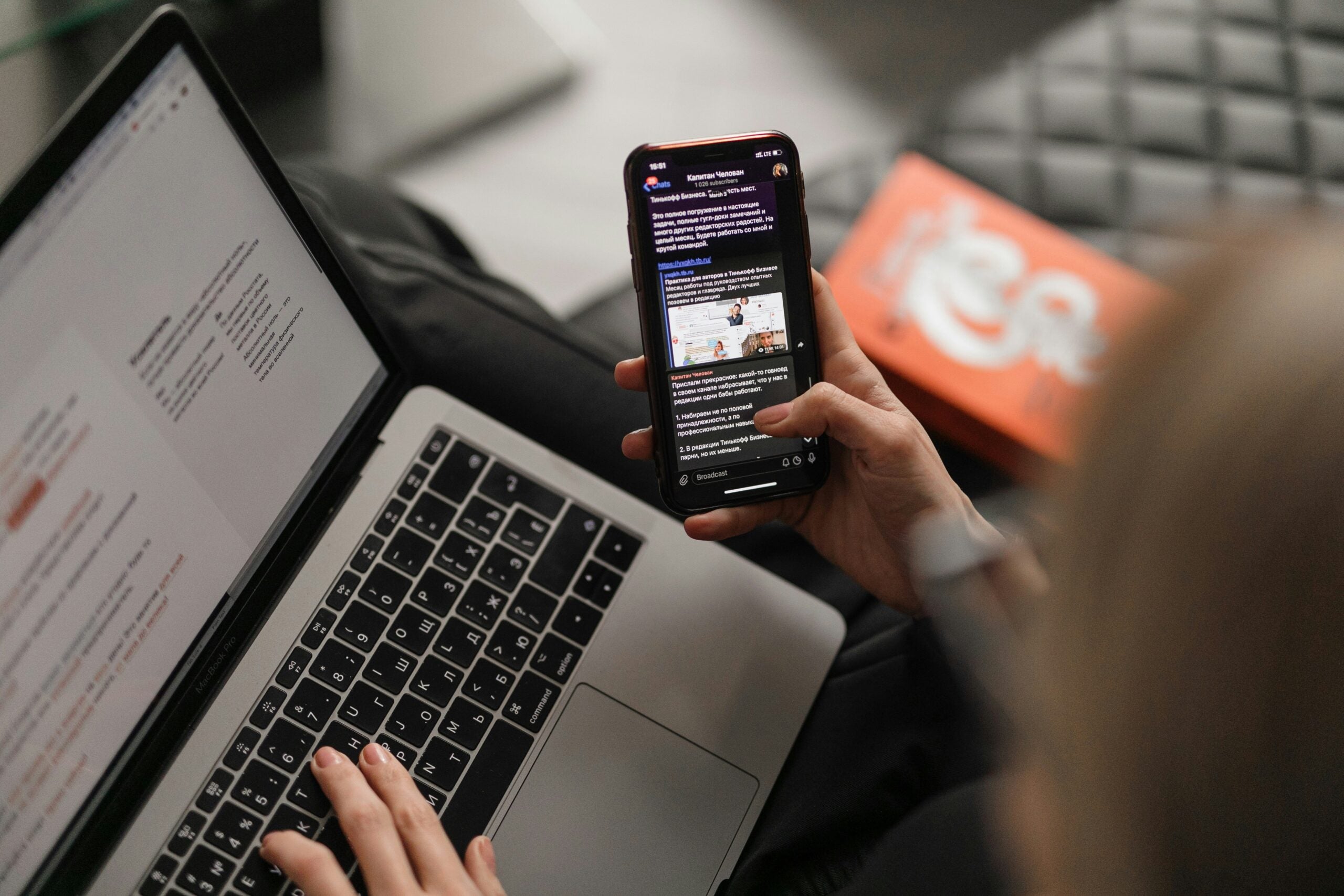 Person looking at phone and computer at same time.