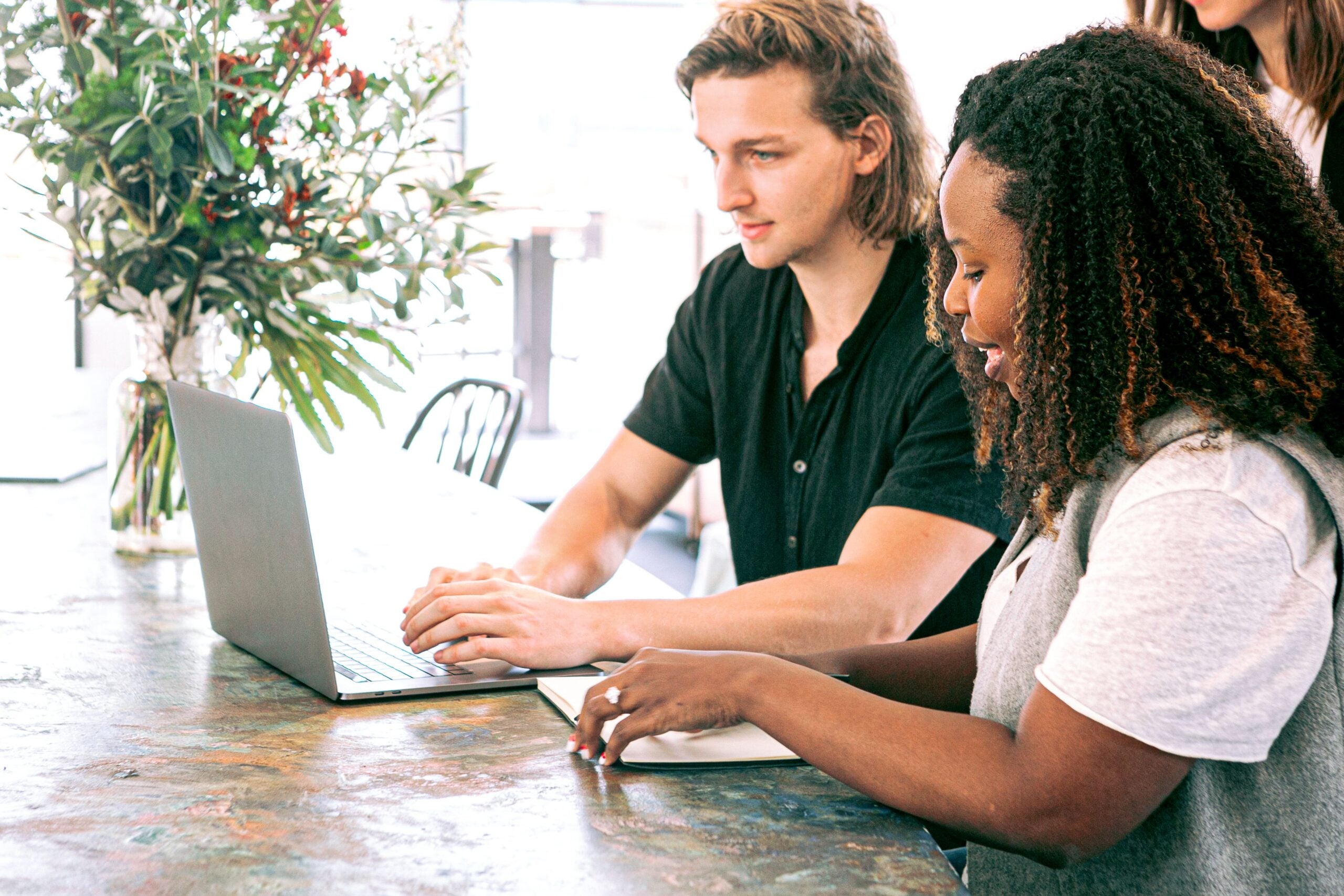 Two people researching at a computer.